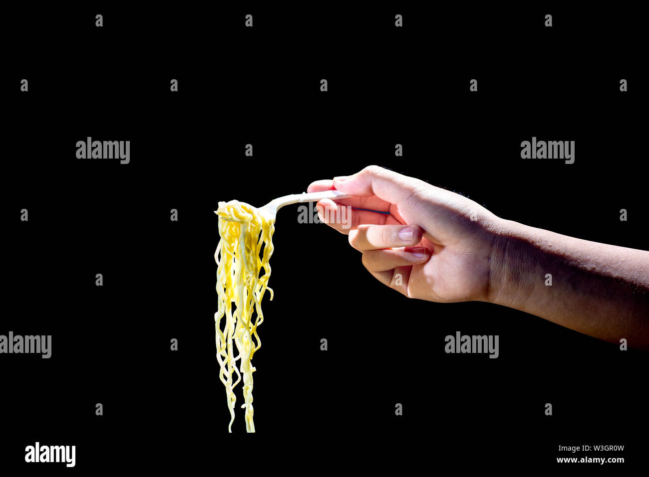 People eat the noodles with fork over black background Stock Photo Alamy