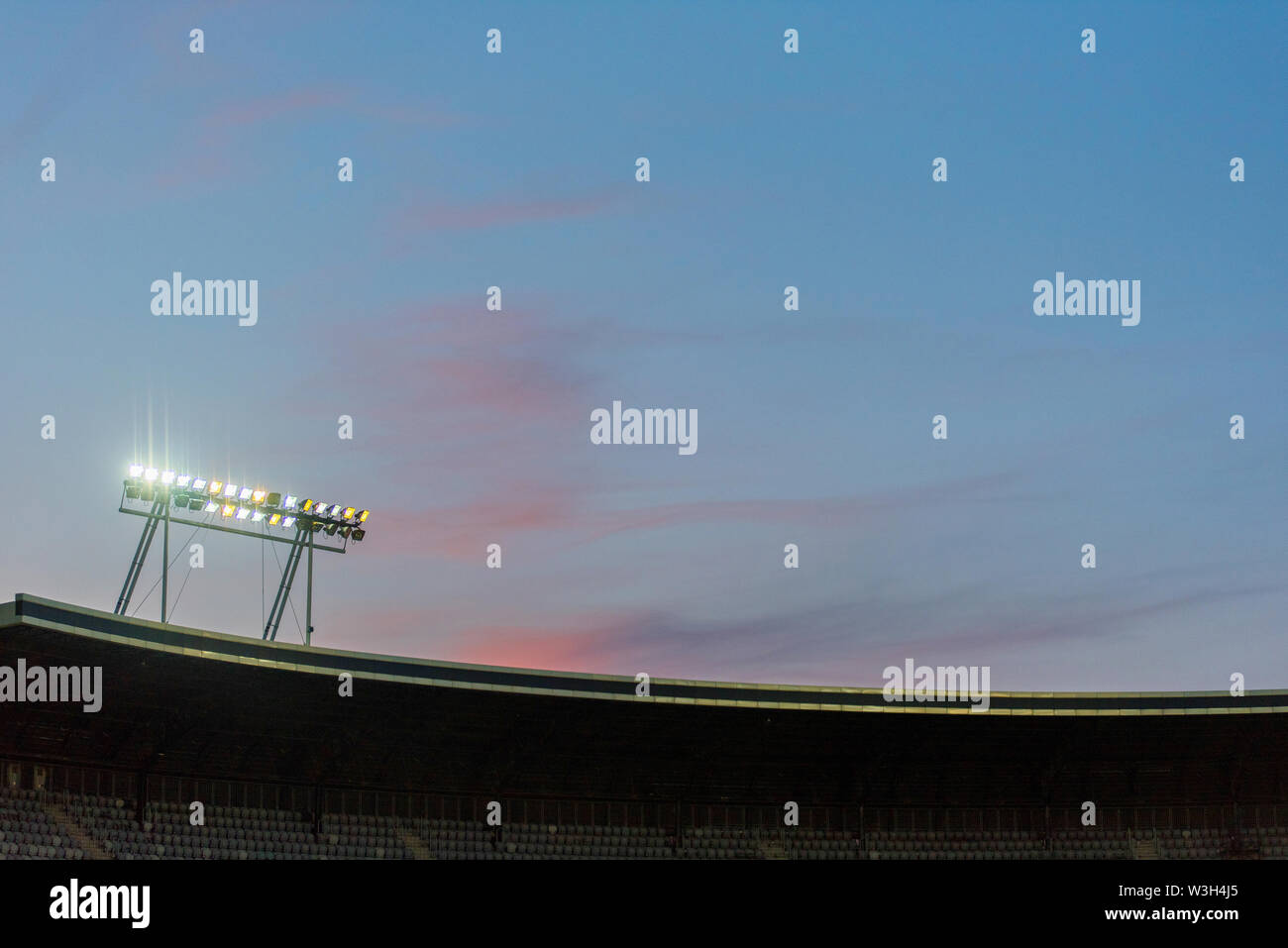 Stadium lights against blue sky during sunset Stock Photo