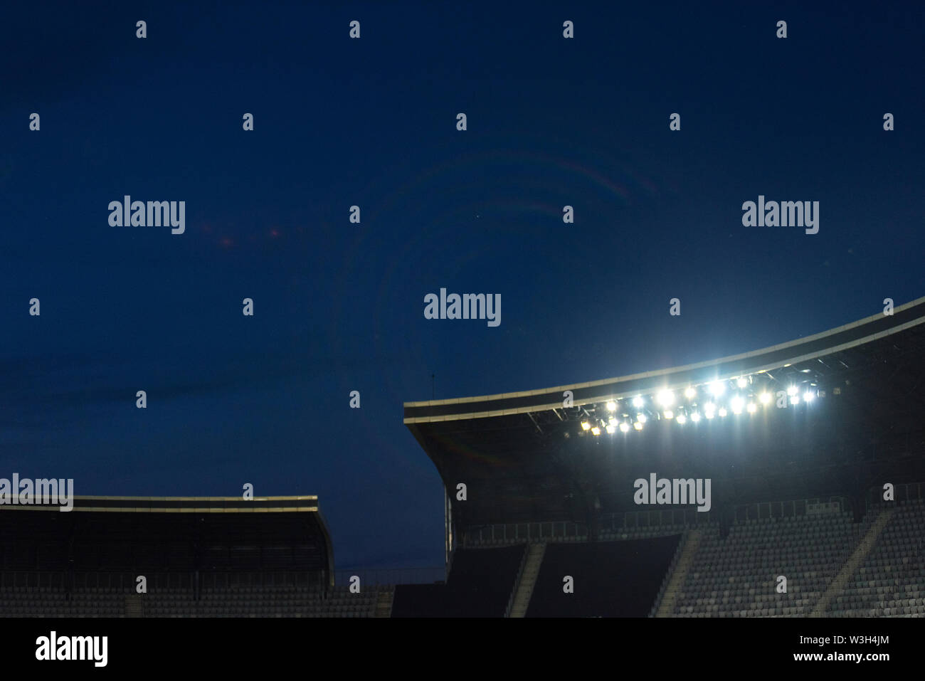 Stadium lights against blue sky during sunset Stock Photo