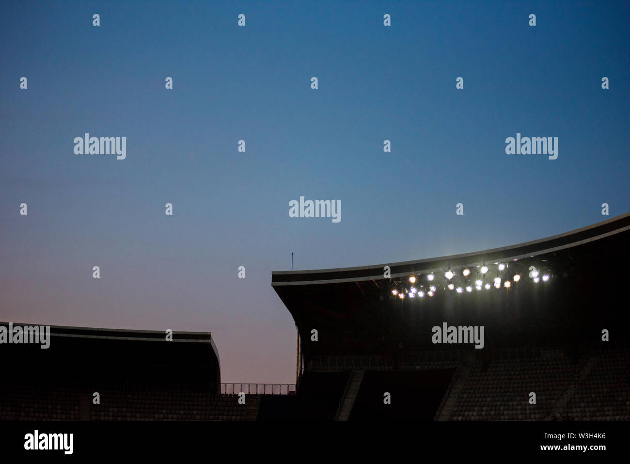 Stadium lights against blue sky during sunset Stock Photo