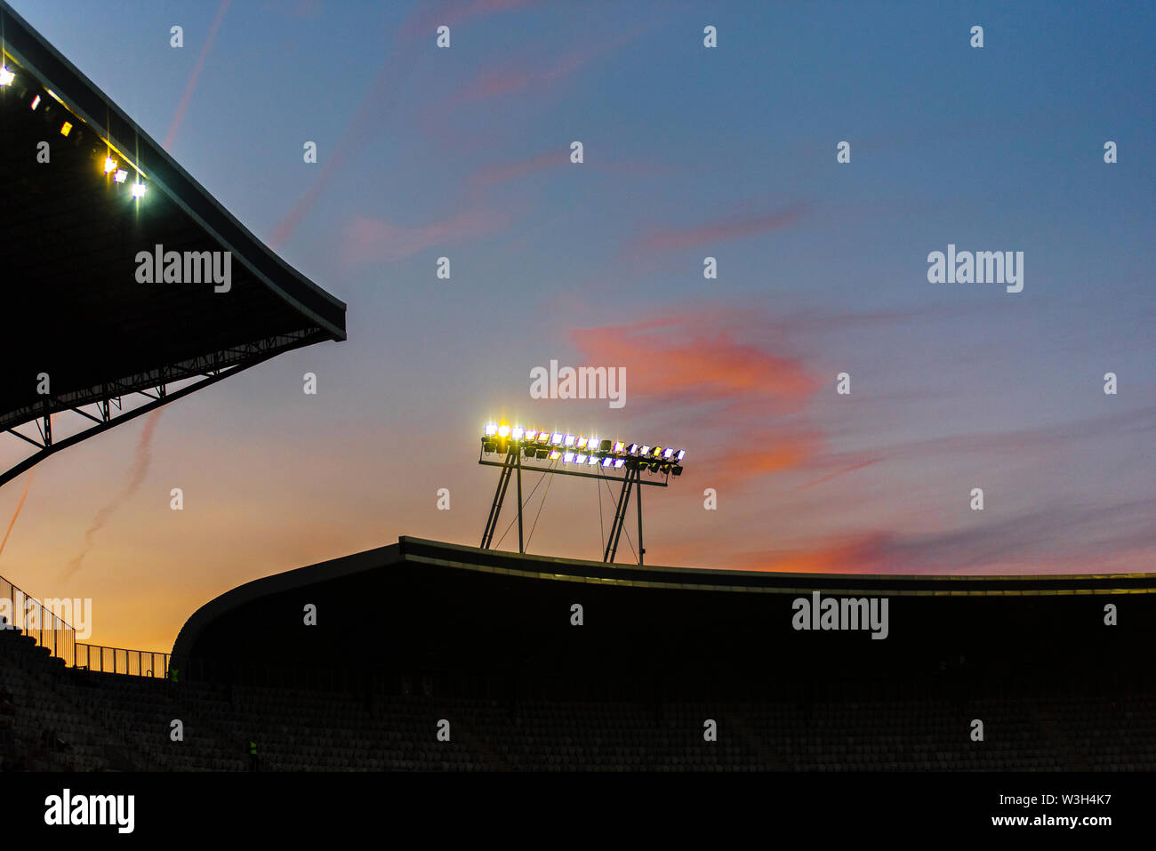 Stadium lights against blue sky during sunset Stock Photo