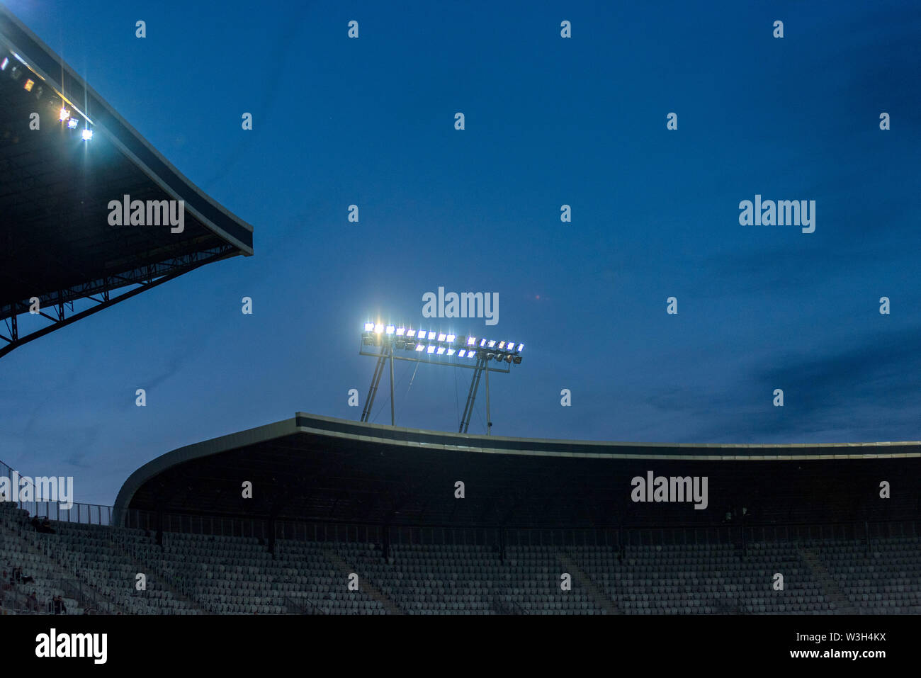 Stadium lights against blue sky during sunset Stock Photo