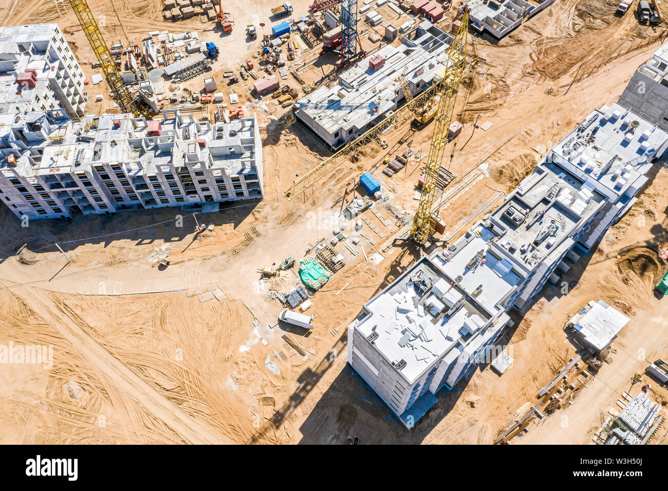 yellow tower cranes working at construction site. building of new ...