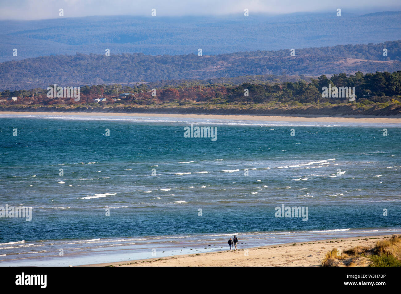 Coles Bay Tasmania, couple walk along sandpiper beach in Coles Bay,Tasmania,Australia Stock