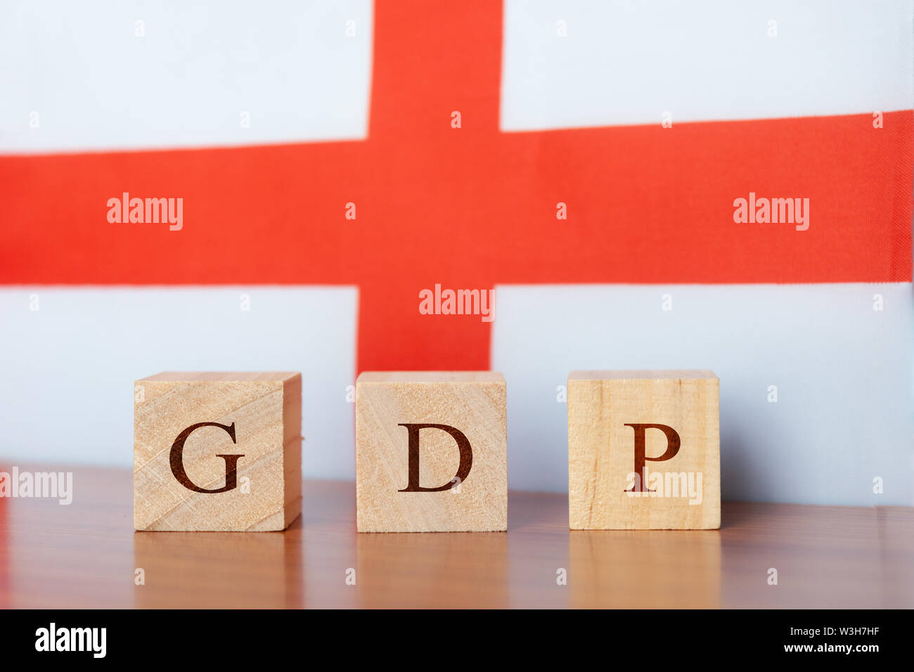 GDP or gross domestic product of England in wooden block letters, England Flag as a background Stock Photo