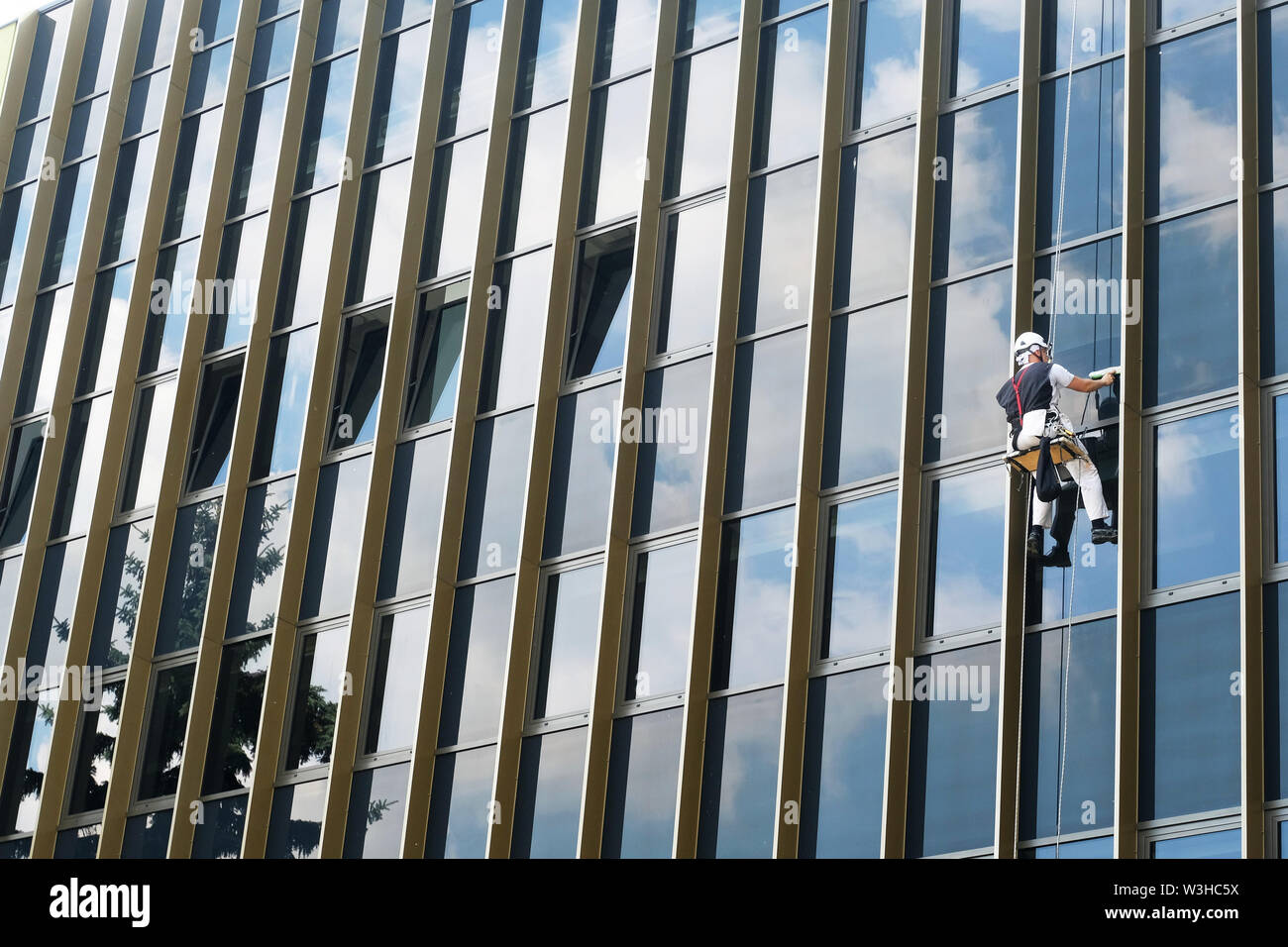 climber window cleaner cleaning exterior glass wall of an office building Stock Photo