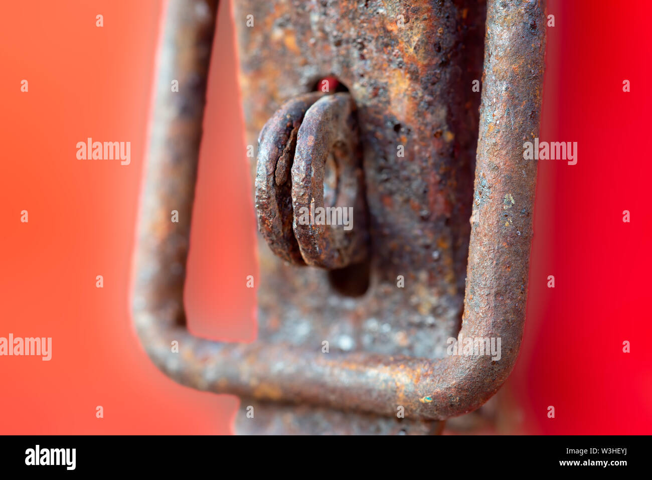Rusty, Weathered Hasp and Staple on Orange, Red Background Stock Photo