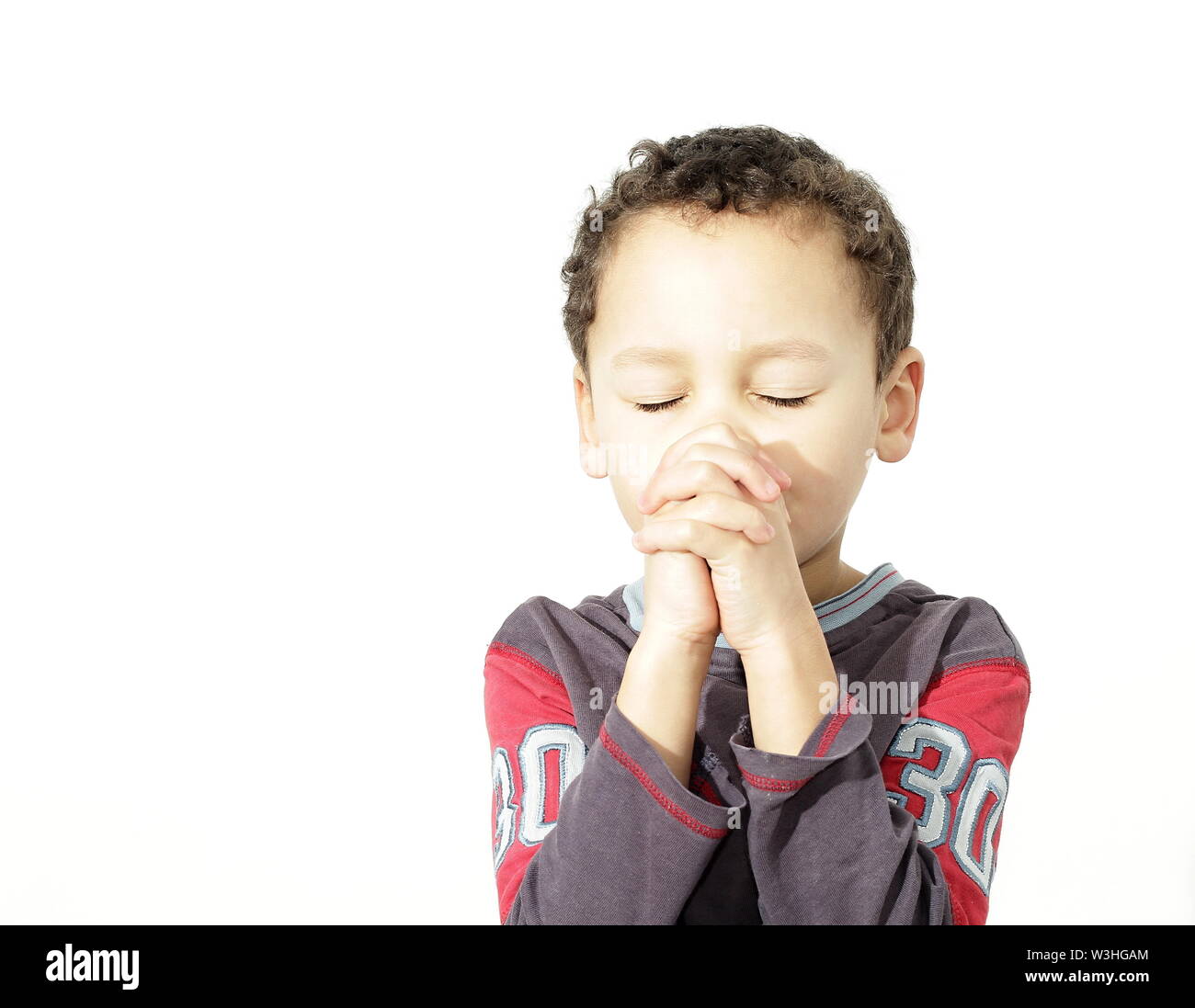 little boy praying to God with hands together stock photo Stock Photo