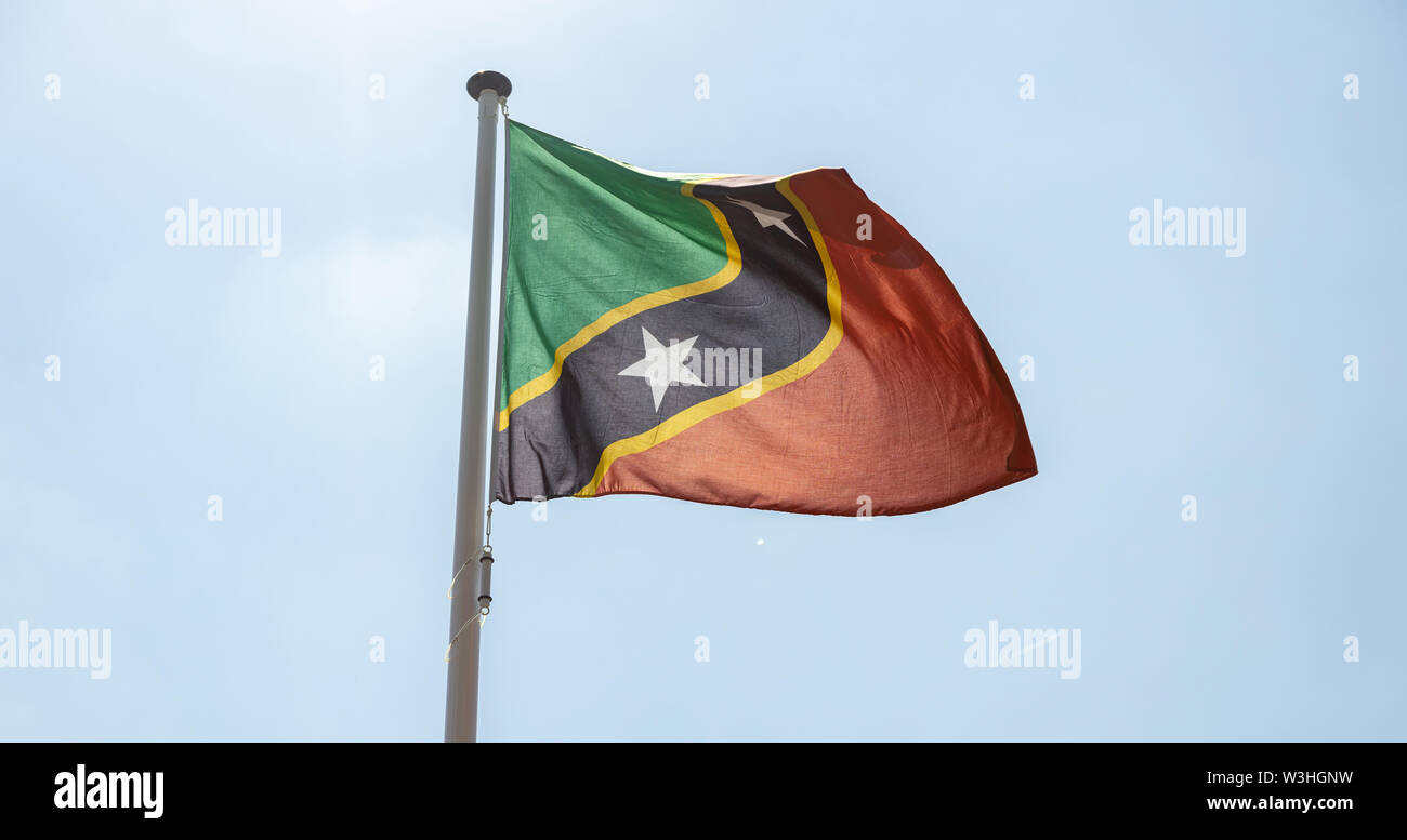 Saint Kitts and Nevis flag, National symbol waving against clear blue sky, sunny day Stock Photo