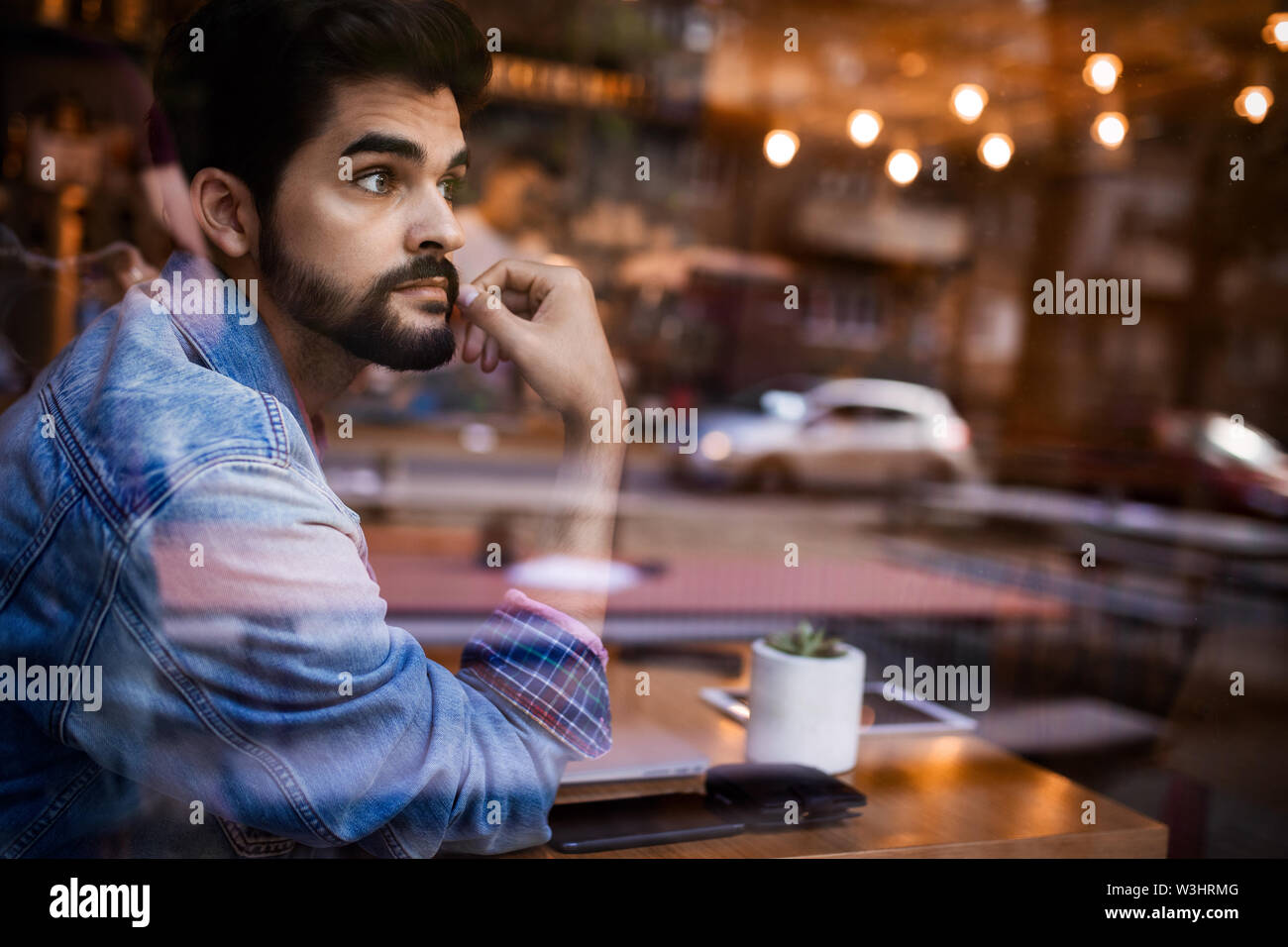 Young man thinking by the bar window Stock Photo