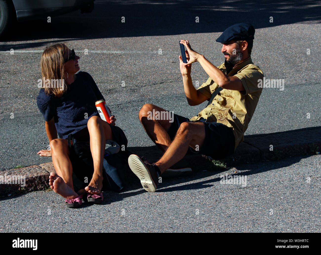 Adult couple taking pictures with mobile phone in Alppiharju district, Helsinki, Finland Stock Photo