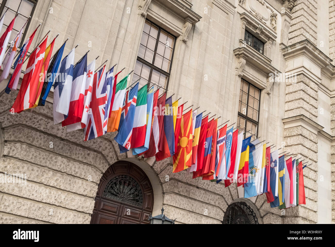 A colourful selection of national flags outside the Hofburg palace building, Vienna, Austria Stock Photo