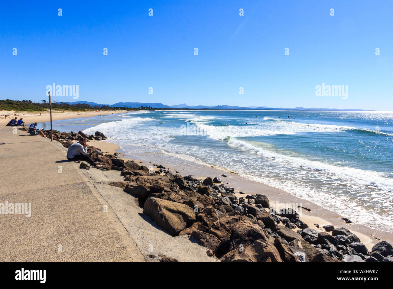Byron Bay, Australia - 14th May 2015: People sitting and looking out to sea. The area is popular with young people. Stock Photo