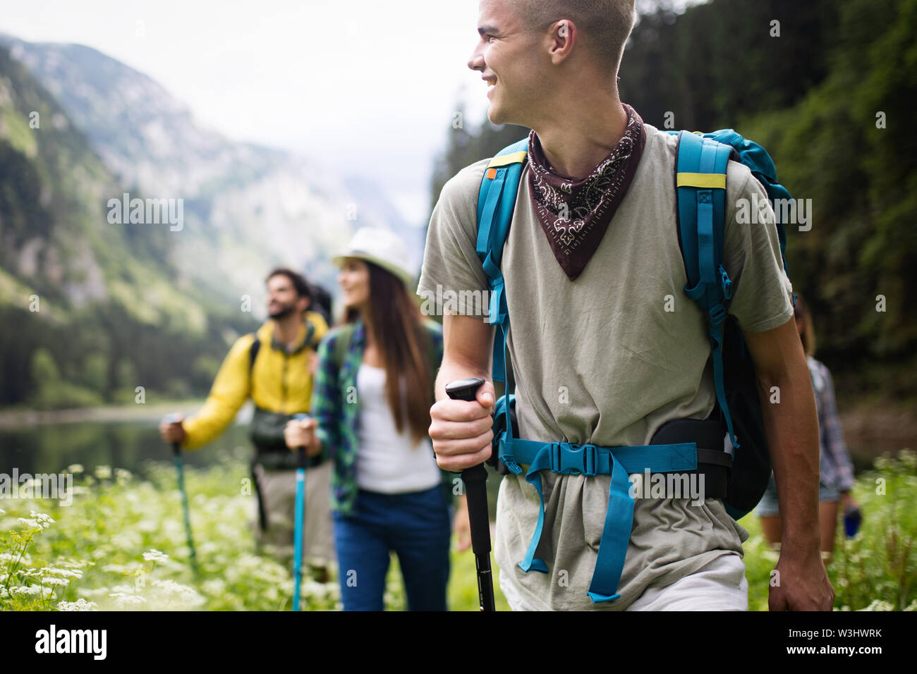 Group of young friends hiking in countryside. Multiracial happy people ...