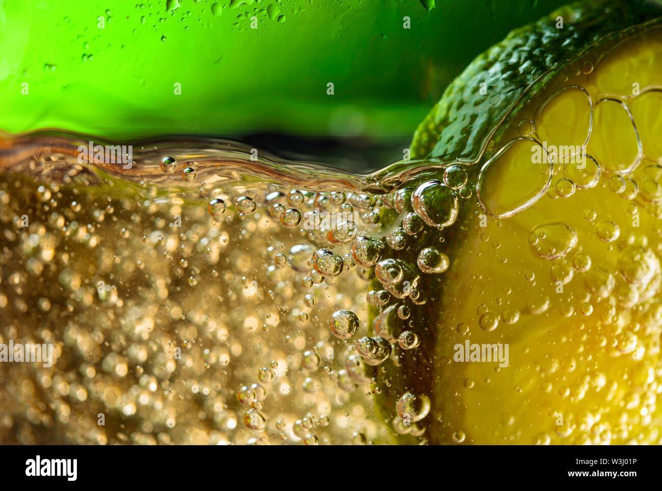 Carbonated drink or cocktail with lime, abstract splashing. Macro shot. Stock Photo