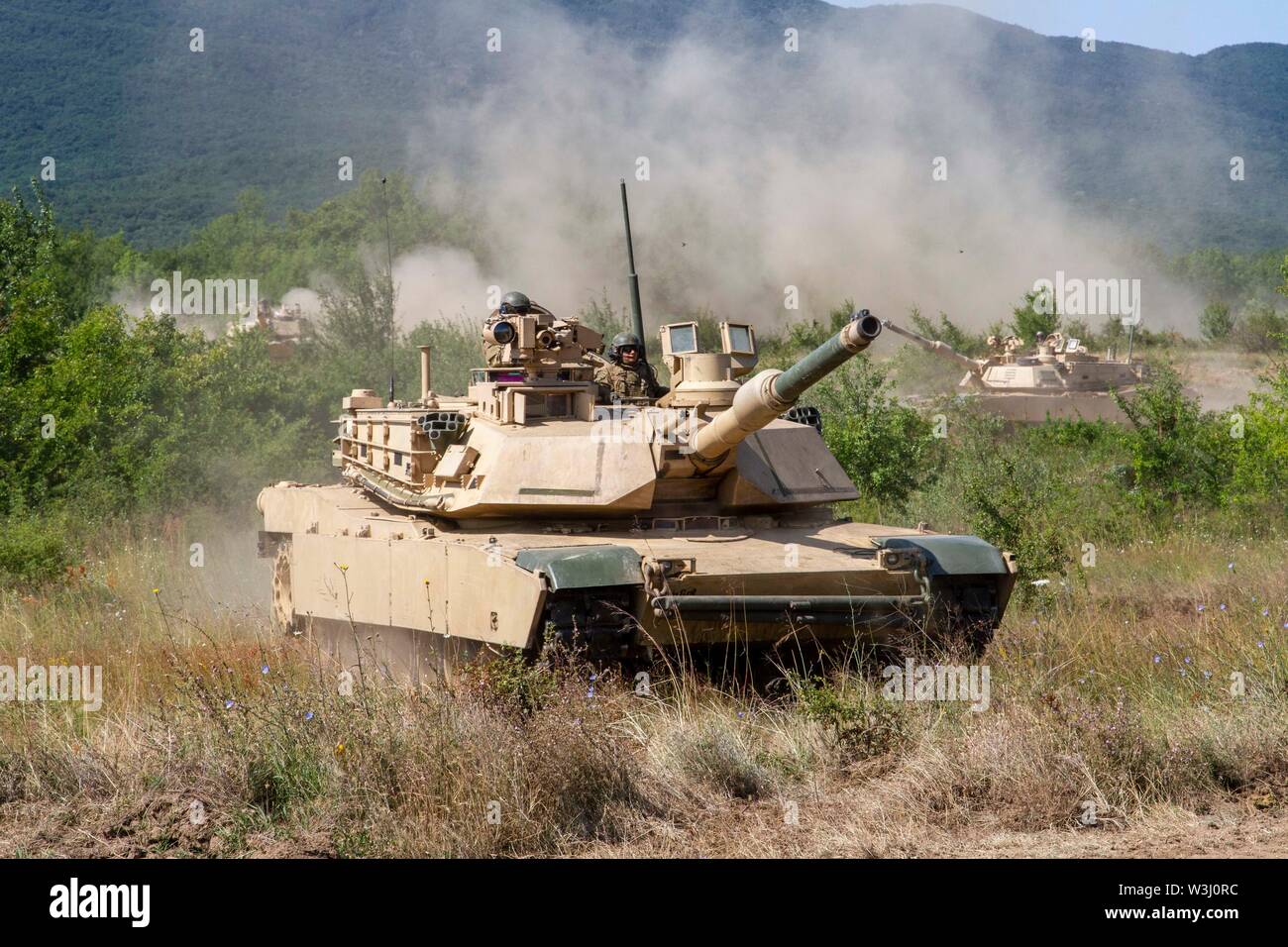 M1 Abrams tanks assigned to 1st Battalion, 16th Infantry Regiment, 1st Armored Brigade Combat Team, 1st Infantry Division maneuver into position during Platinum Lion 19 at Novo Selo Training Area, Bulgaria, July 12, 2019. The training exercise allows the participating units to share military knowledge and tactics to increase the interoperability and strengthen the bond between the nations. (U.S. Army photo by Staff Sgt. True Thao) Stock Photo