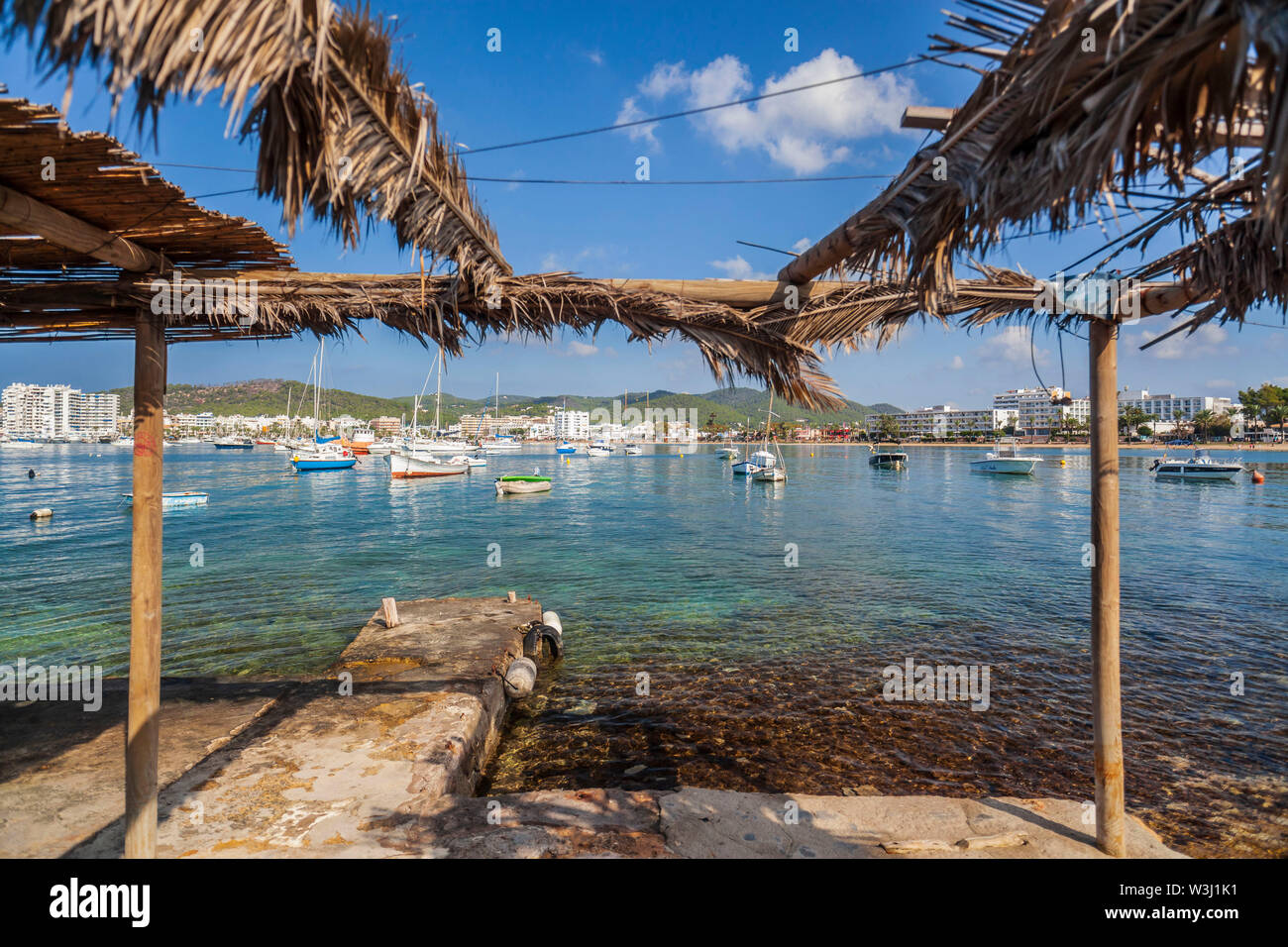 Old stone pier and fisherman house in bay and beach of Sant Antoni de Portmany, Ibiza Island, Balearic islands. Spain. Stock Photo