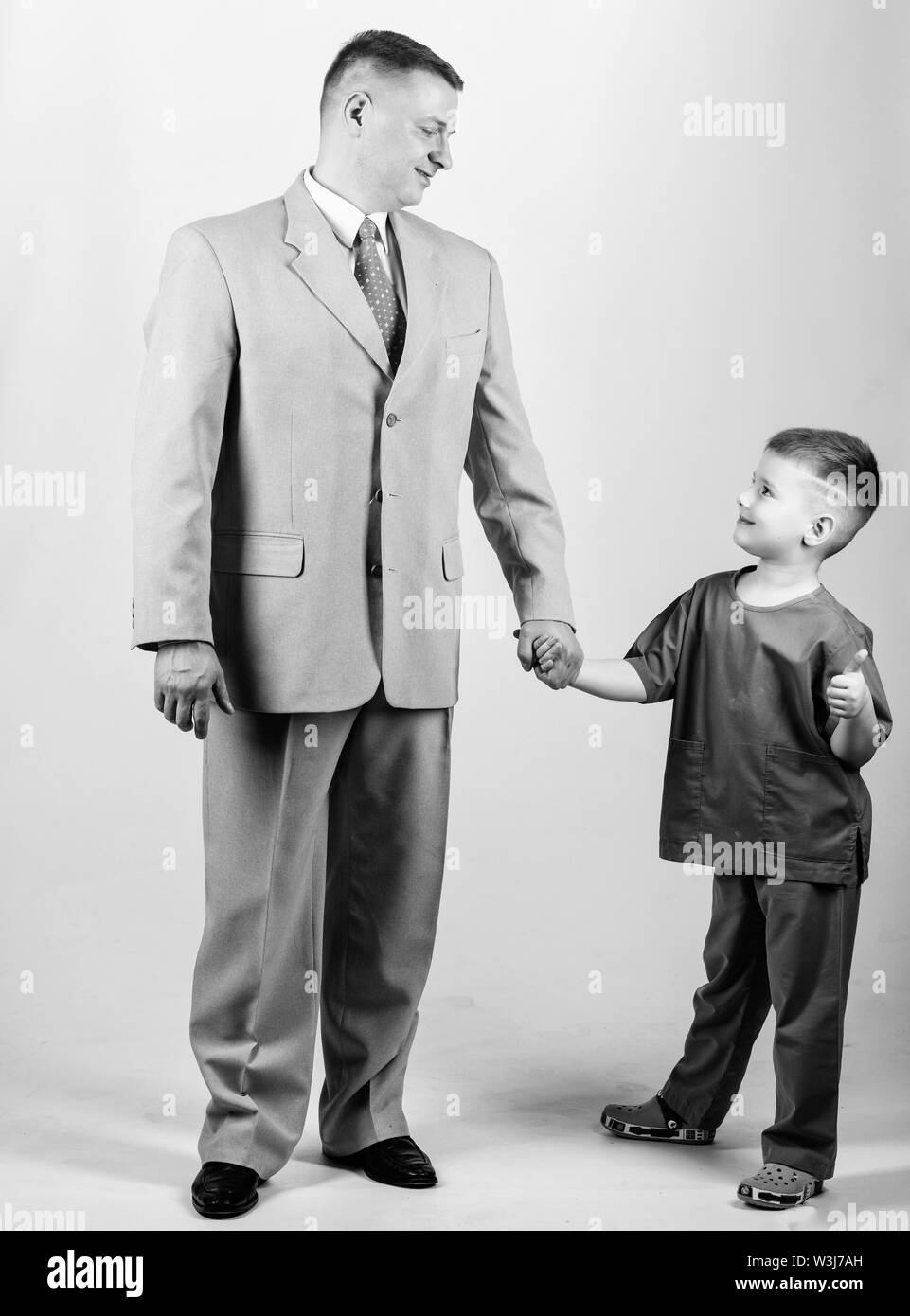 togetherness. trust and values. fathers day. family day. father and son in business suit. male fashion. happy child with father. business partner. small boy doctor with dad businessman. childhood. Stock Photo