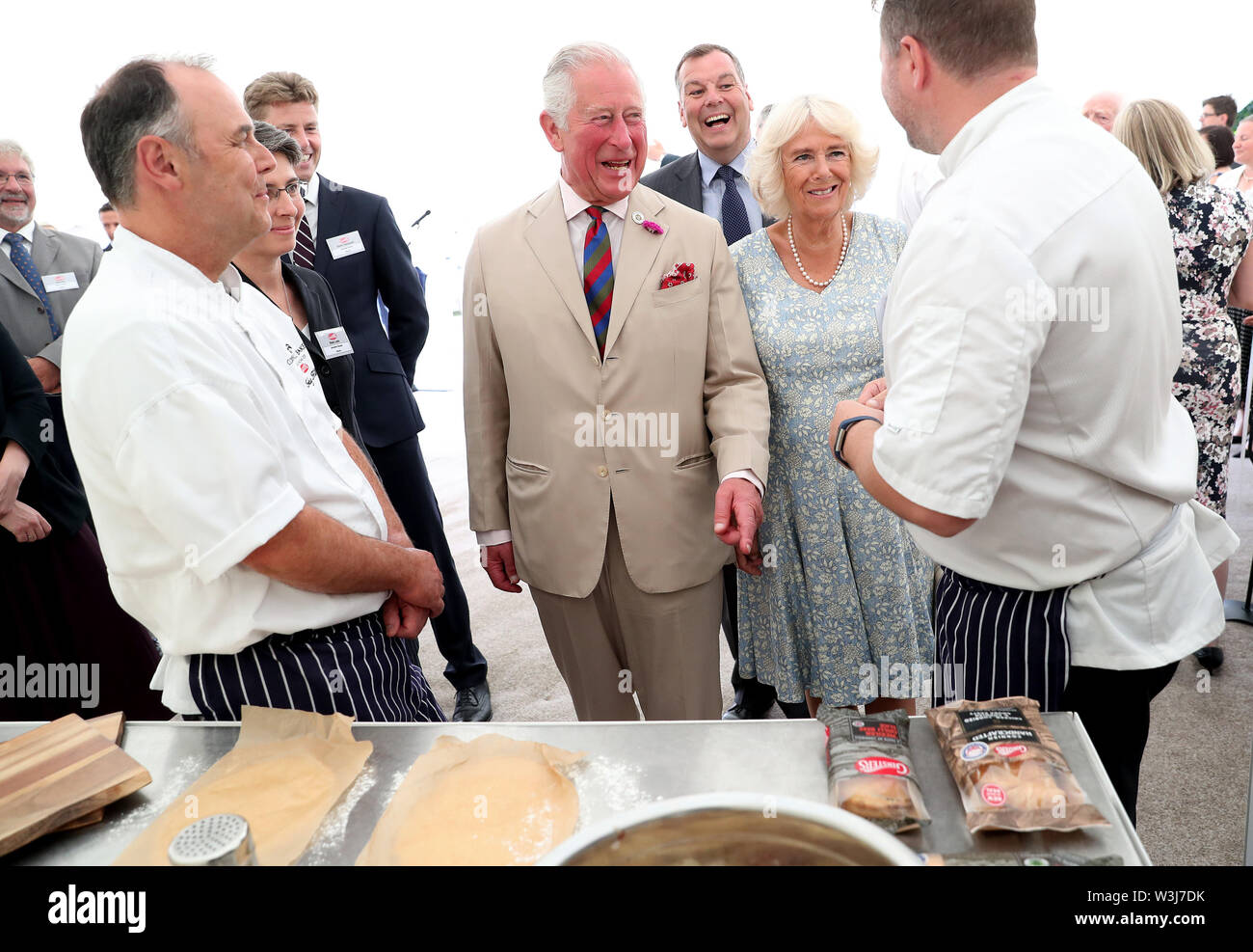The Prince of Wales and the Duchess of Cornwall speak to staff ahead of a garden party to celebrate the 50th anniversary of Ginsters bakery in Callington, as part of their visit to Cornwall. Stock Photo