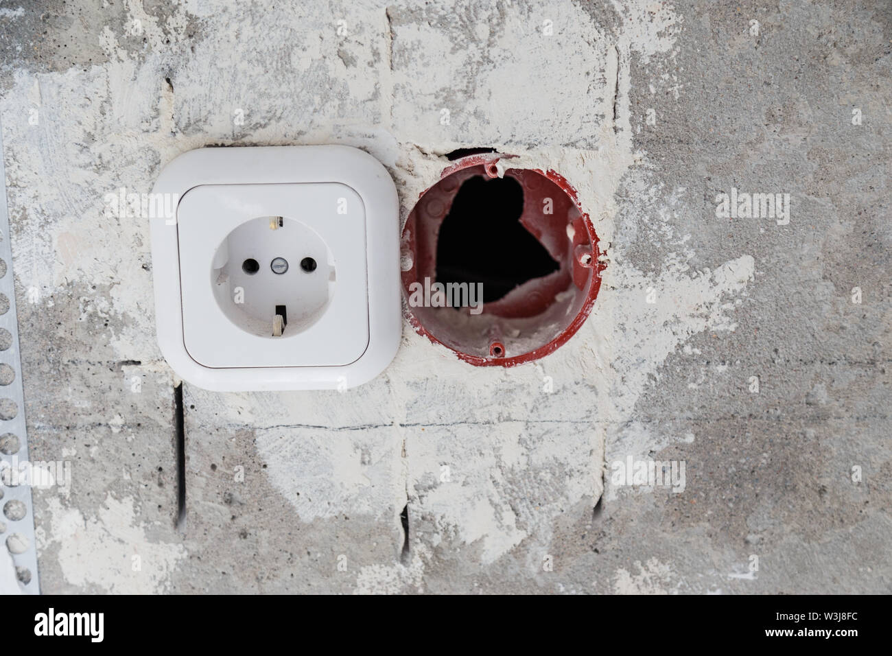 Electrical socket hole on concrete wall. Under construction electrical
