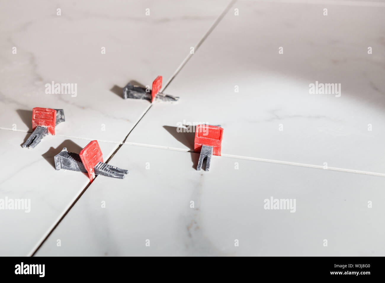 Tile leveling system with plastic clips and wedges. Stock Photo