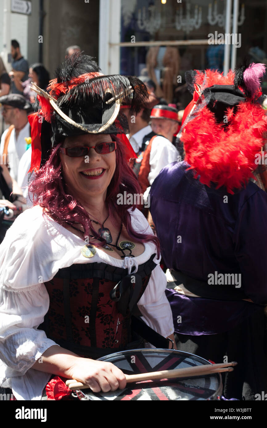 Smiling female drummer taking part at Pirate Day parade in the the old