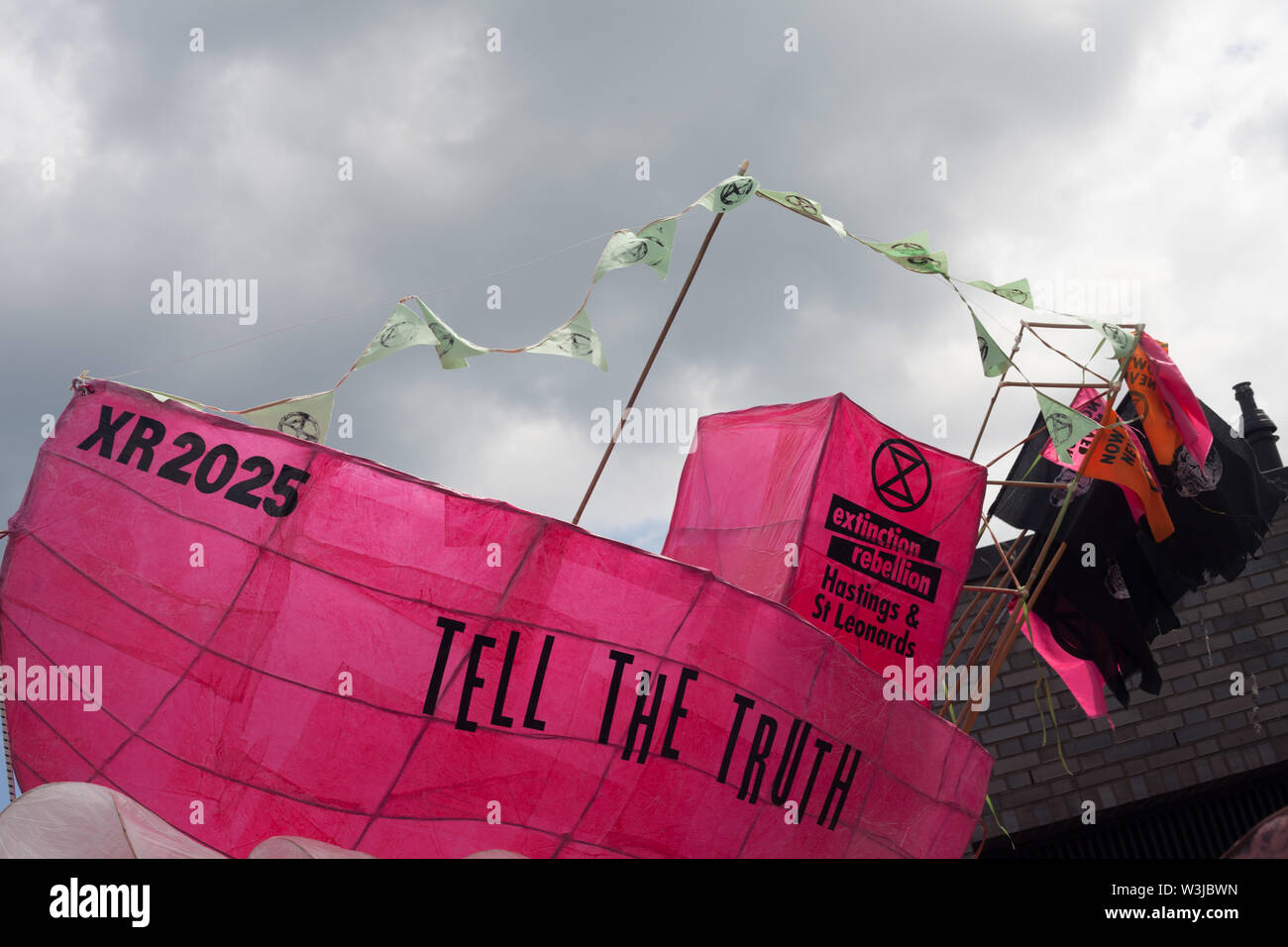 Pink fishing boat prop used by Extinction Rebellion promoting the movement against climate breakdown at Hastings Pirate Day, Hastings, Sussex, UK Stock Photo