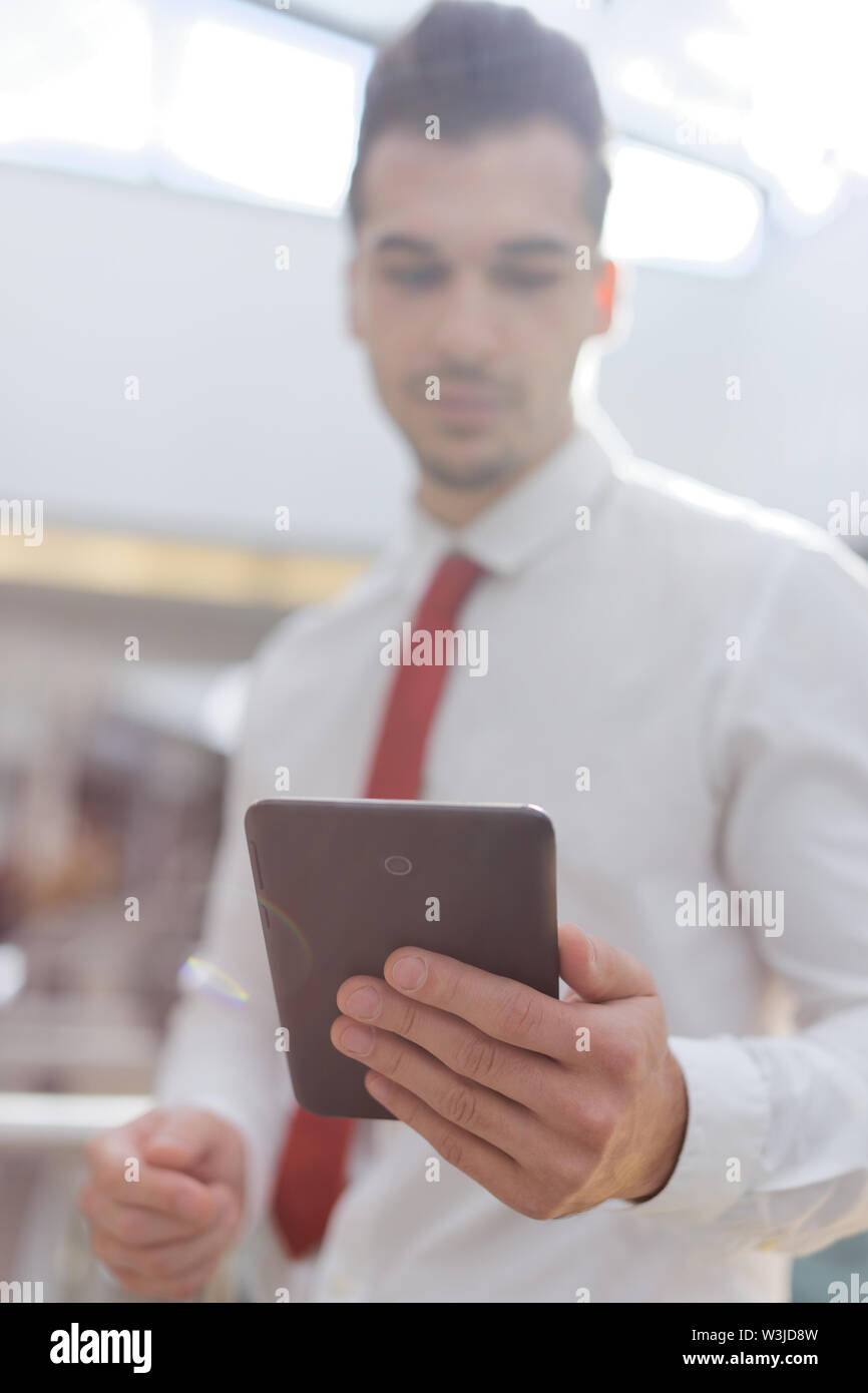 Young professional businessman holding tablet in office center depth of field Stock Photo