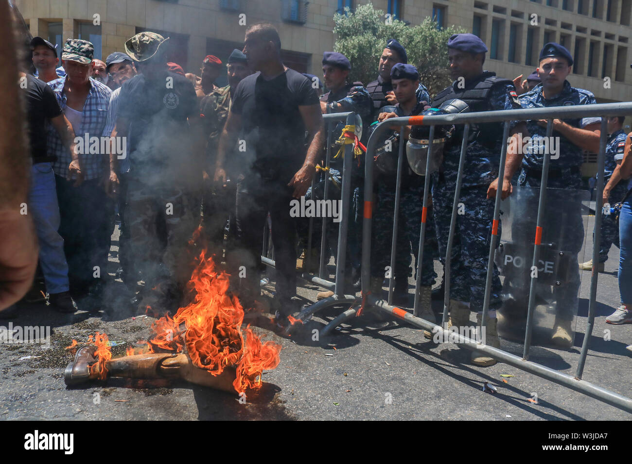 Beirut Lebanon. 16th July 2019. Retired soldiers of the Lebanese  army set fire to a veteran's prosthetic legs as they  protest against cuts in state pensions and over austerity budget measures being debated by in Parliament as  planned cuts have unleashed a wave of public discontent, which have  targeted pensions, wages, services and social benefits.Credit: amer ghazzal/Alamy Live News Stock Photo