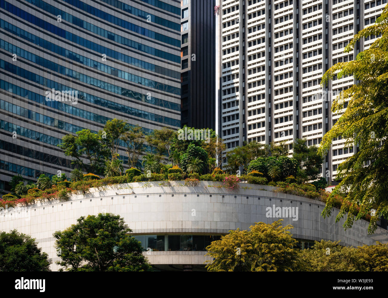 Modern glass buildings with garden and trees on roof in Singapore Stock Photo