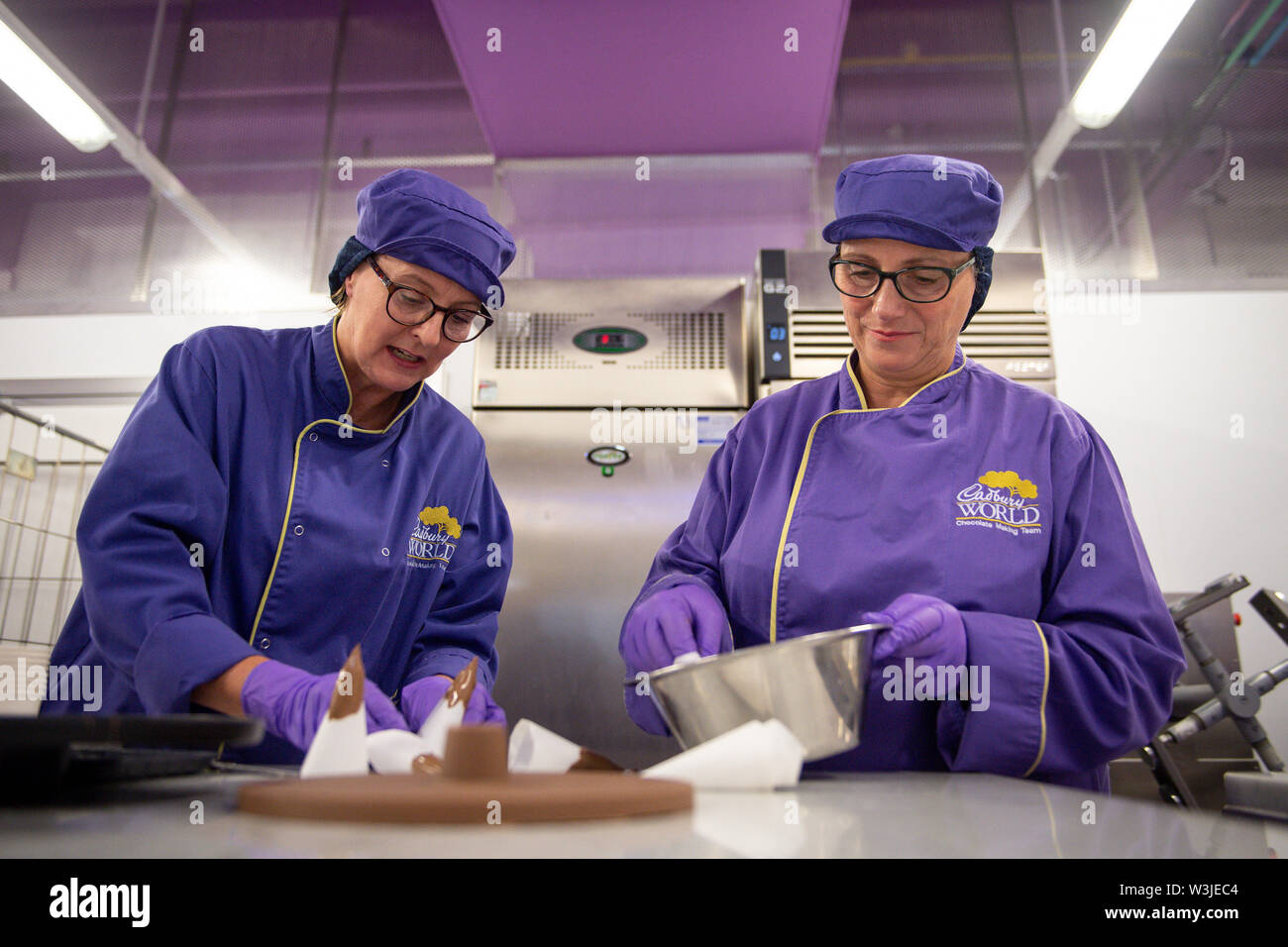 Cadbury World chocolatiers Dawn Jenks and Donna Oluban add the finishing touches to their chocolate recreation of the Apollo 11 moon landing at Cadbury World in Birmingham, 50 years to the day since the US mission to put men on the Moon lifted off. Stock Photo