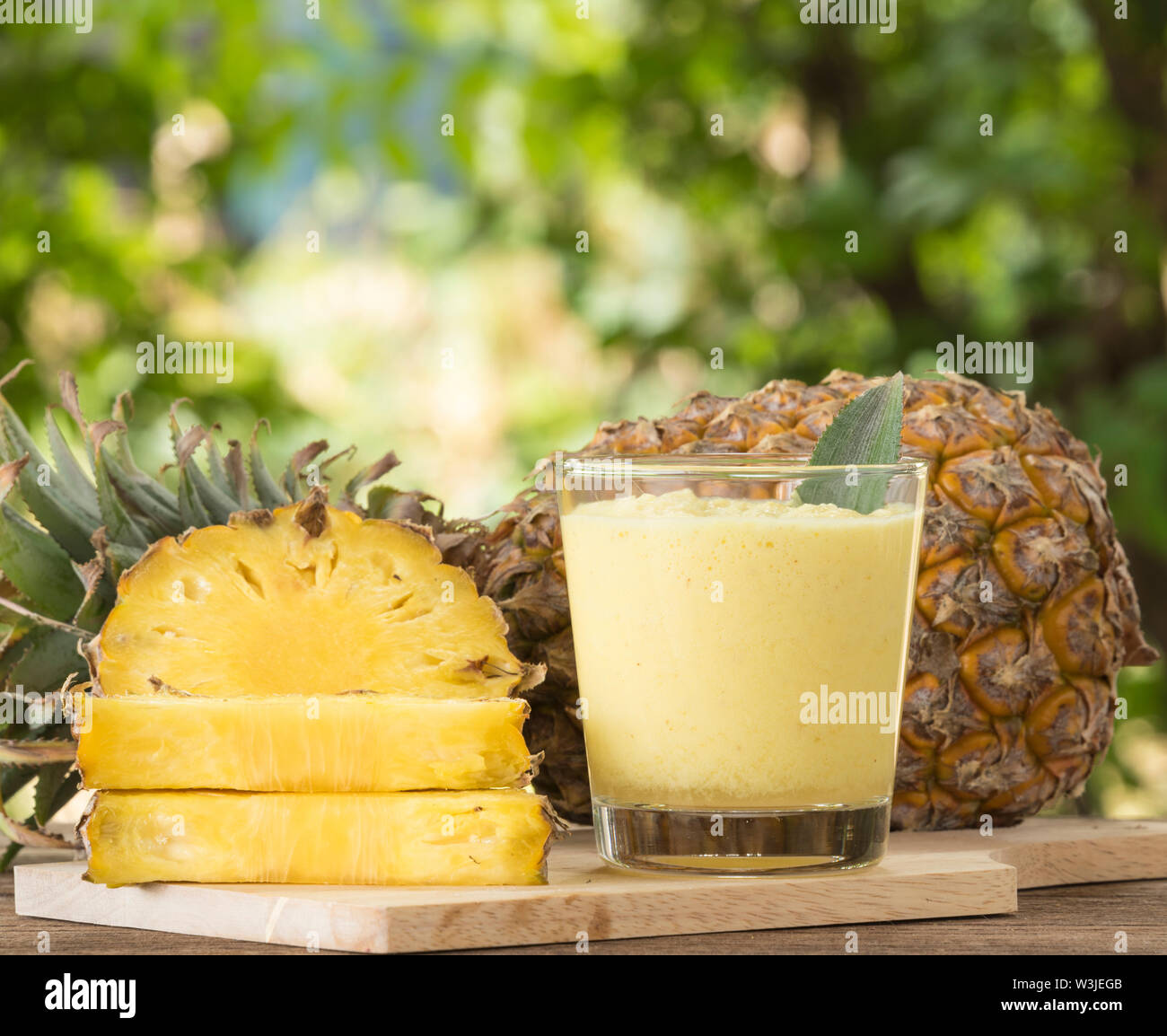 Pineapple juice and pineapple slice placed on a wooden table. Stock Photo