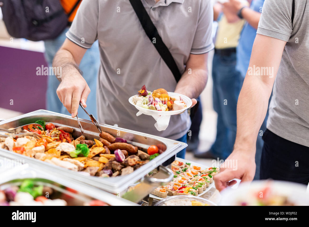 https://c8.alamy.com/comp/W3JF02/close-up-of-man-holding-plate-and-scooping-food-at-buffet-table-catering-in-hotel-or-restaurant-W3JF02.jpg