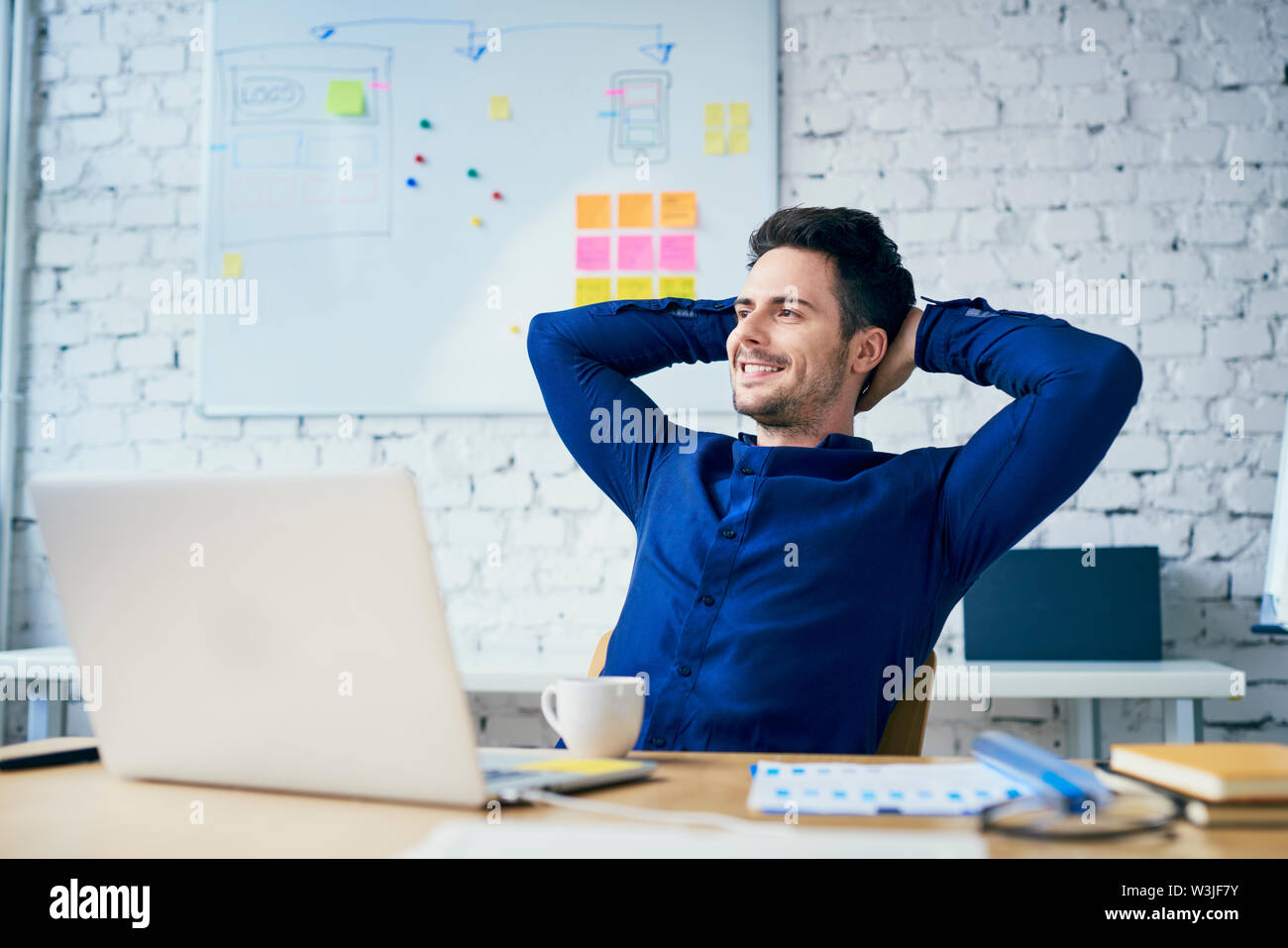 Satisfied young man sitting hi-res stock photography and images - Alamy