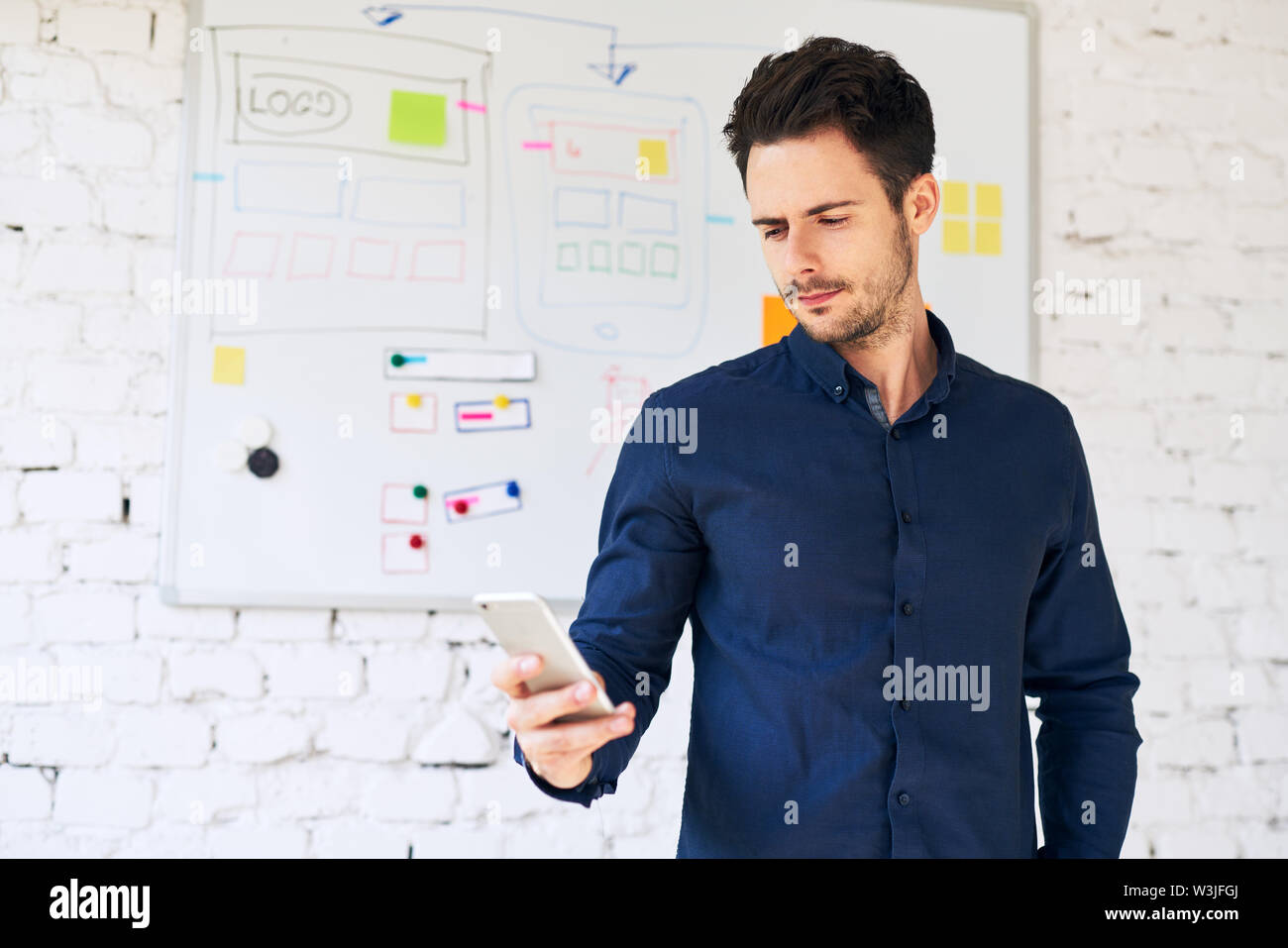 Mobile application designer using smartphone, doing usability tests Stock Photo