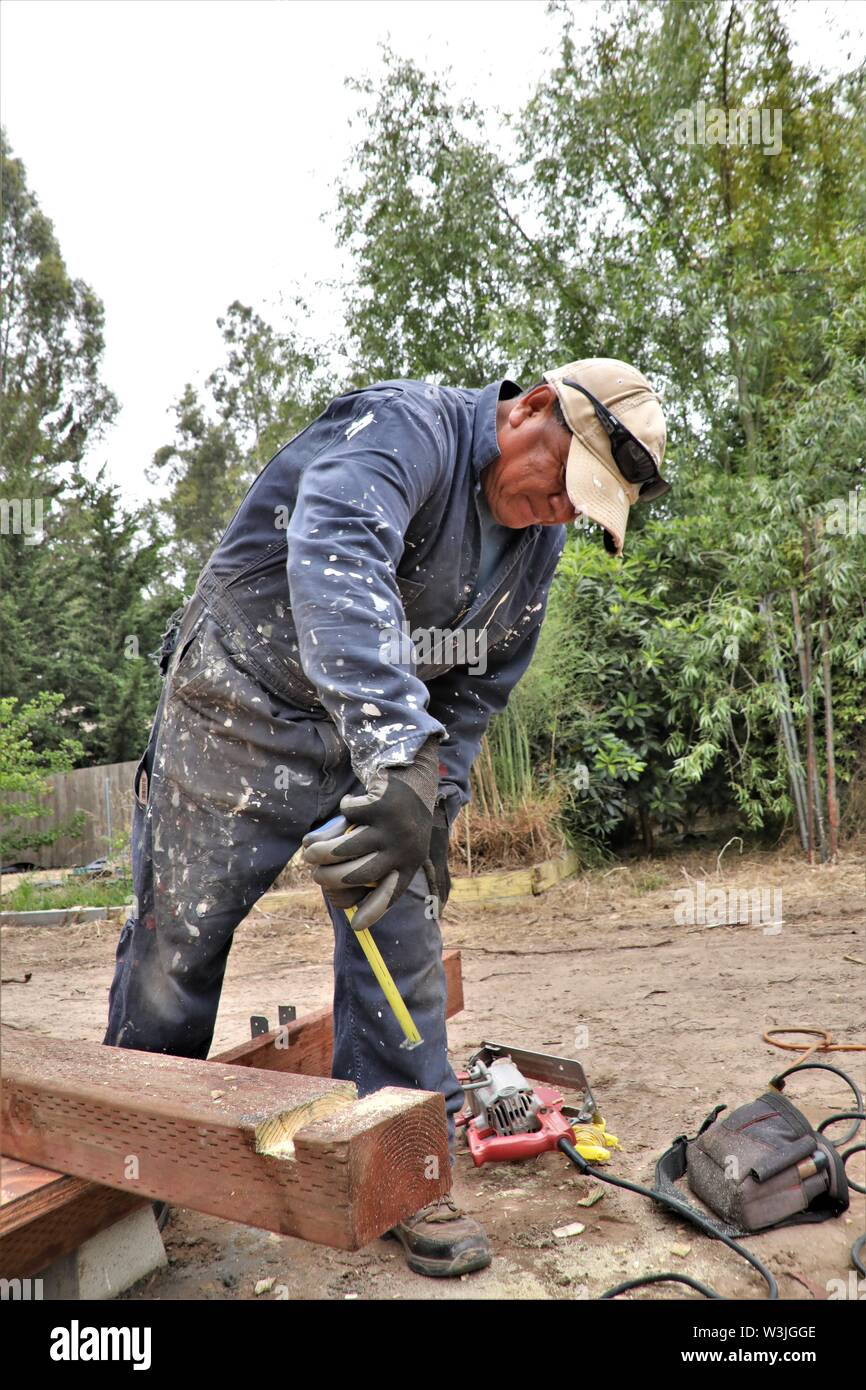 Latin workers working on garden shed in California USA and resting for