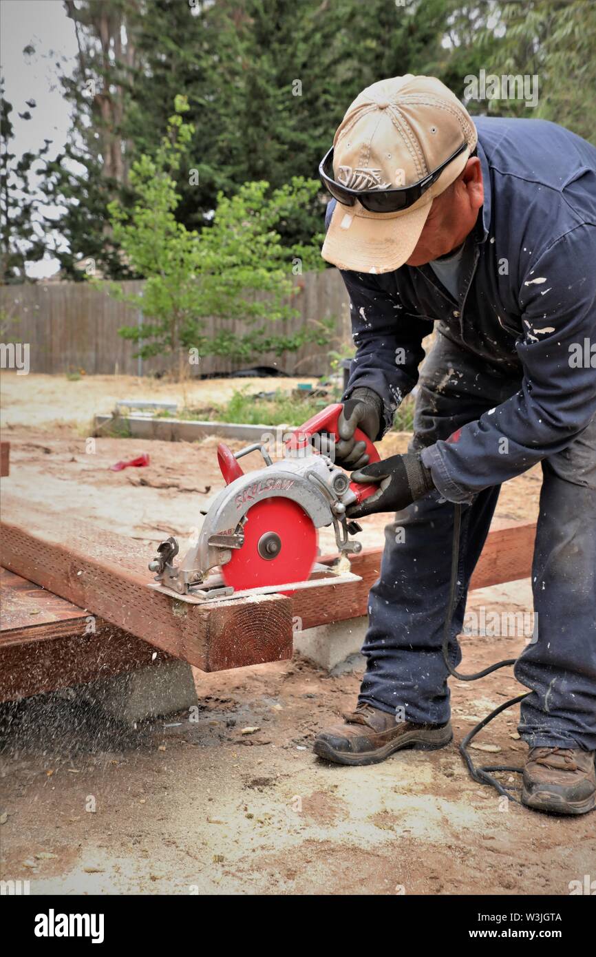Latin workers working on garden shed in California USA and resting for