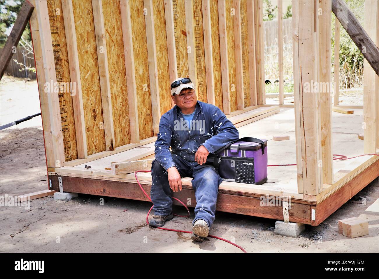 Latin workers working on garden shed in California USA and resting for