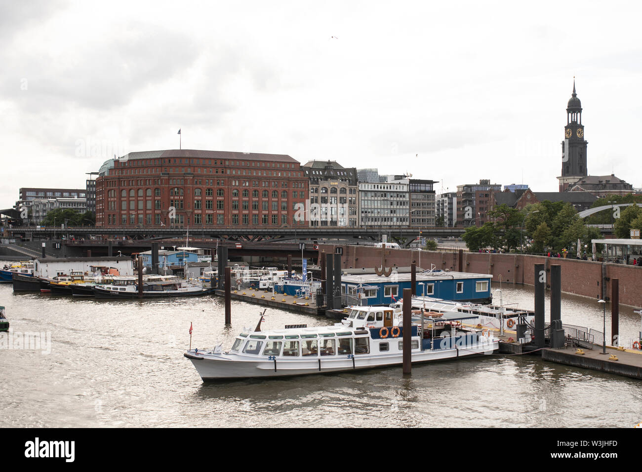 Boats in Binnenhafen canal looking toward Otto-Sill-Brücke bridge in the Hafencity area of Hamburg, Germany, with St Michaels church in the background. Stock Photo