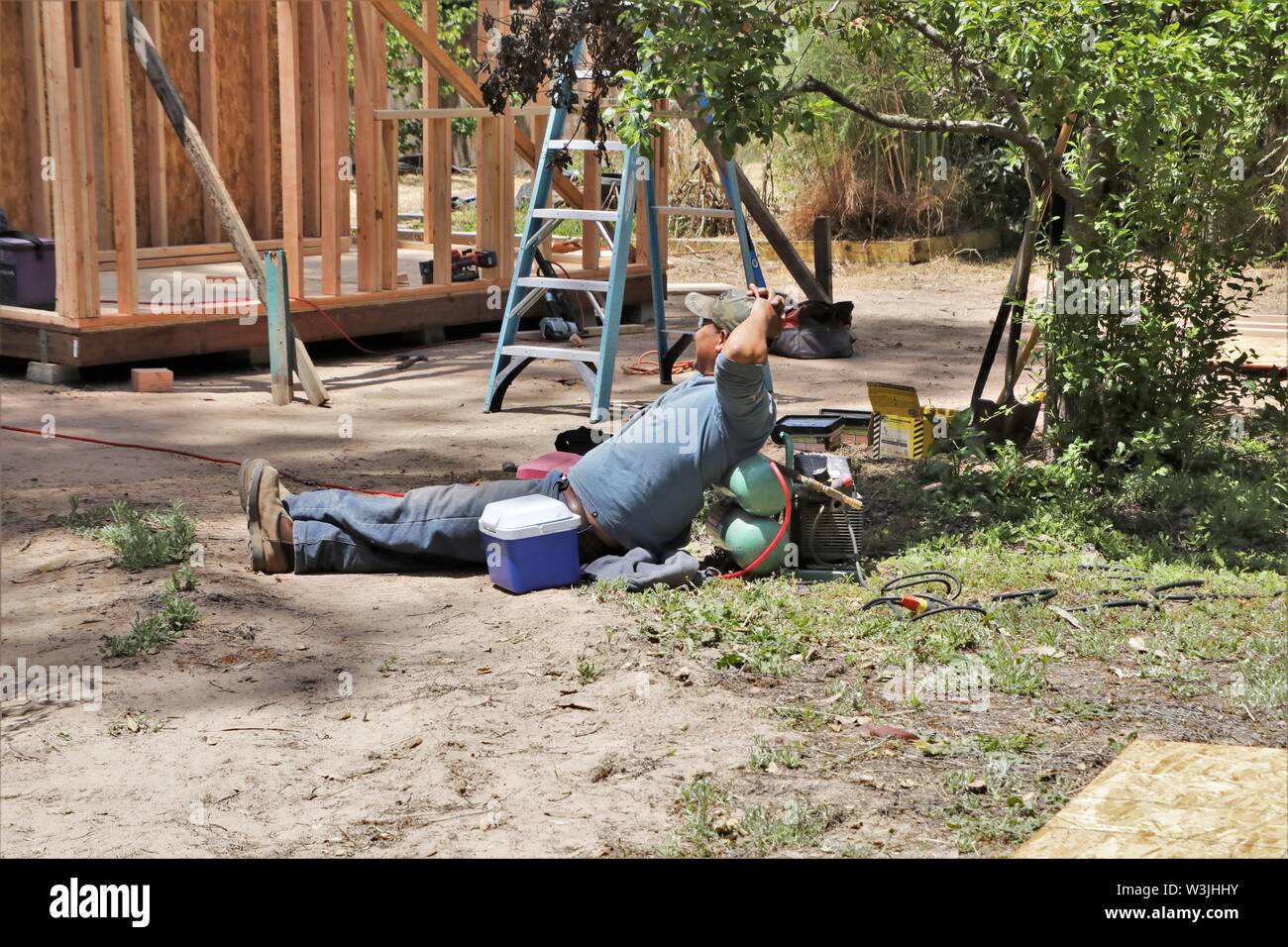 Latin workers working on garden shed in California USA and resting for