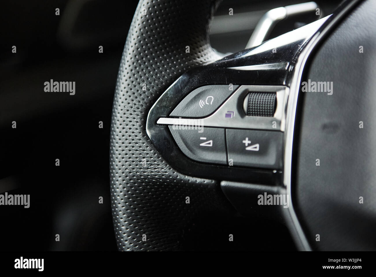 selective focus of steering wheel near gear shift handle in luxury car