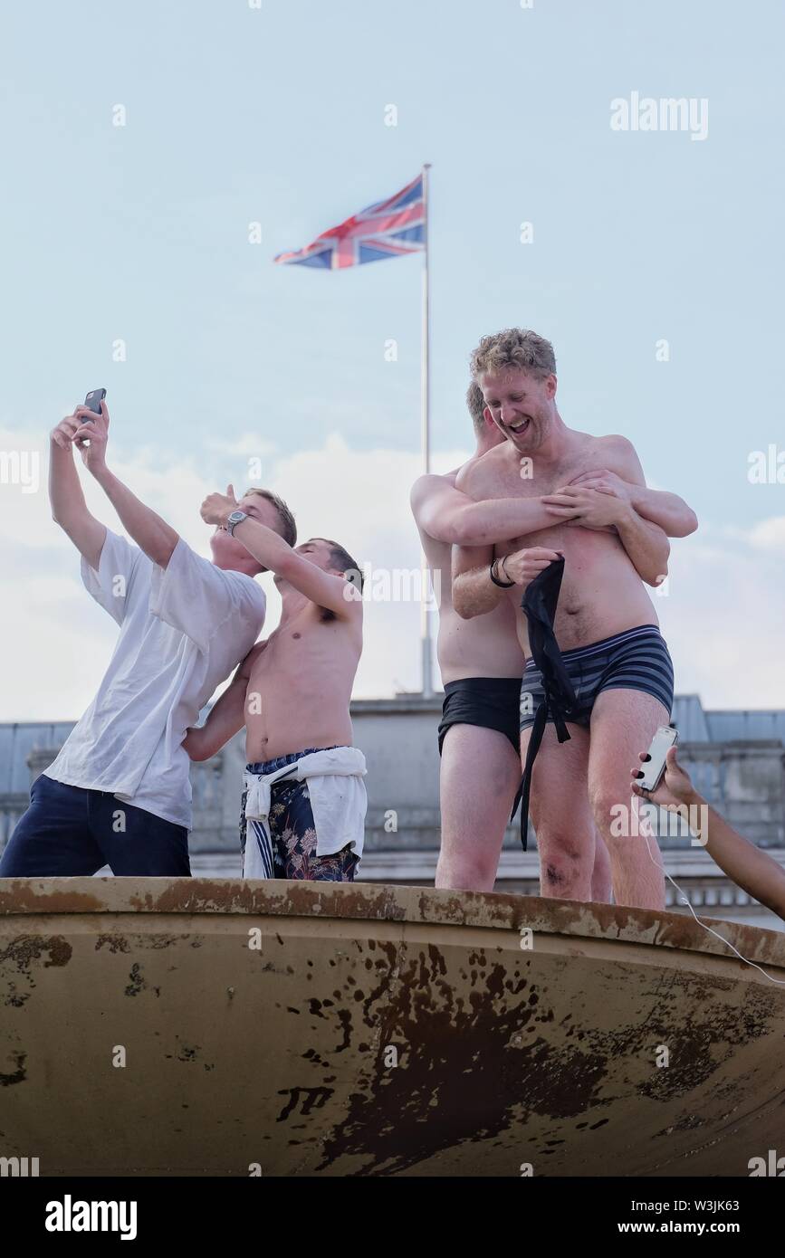Male cricket hug and take selfies whilst celebrating England's World Cup Victory in Trafalgar Square's Fountains. Stock Photo
