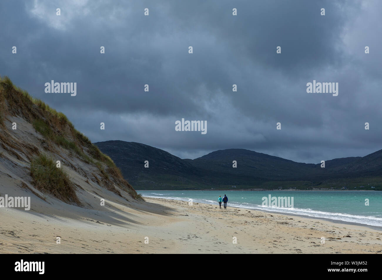 Man and woman walking on the beach at Luskentyre, Isle of Harris, Scotland Stock Photo