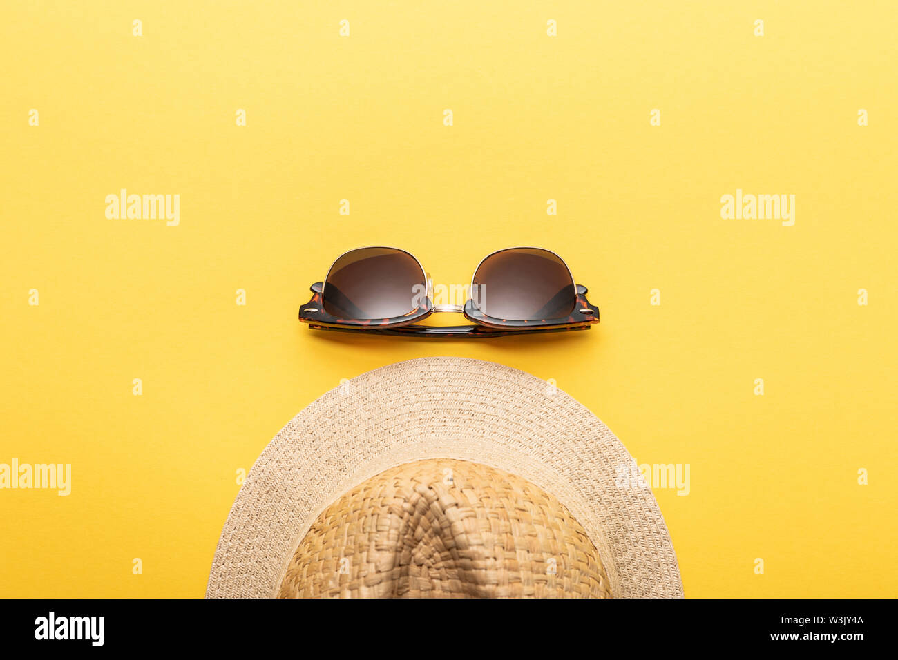 top view of straw summer hat and sunglasses on yellow background Stock ...