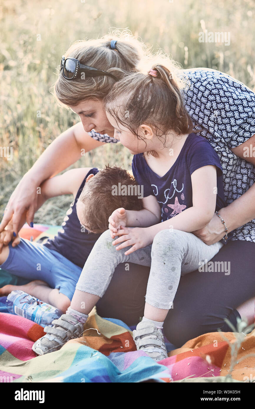 Family spending time together on a meadow, close to nature. Parents and children playing together. Candid people, real moments, authentic situations Stock Photo