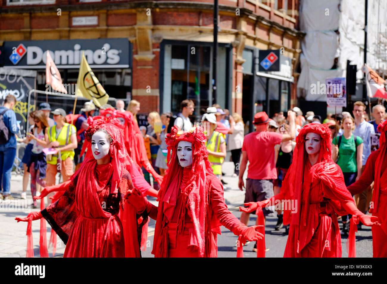 Bristol, UK, 16th July 2019. Red Brigade at Day 2 of the Extinction rebellion movement summer uprising, the occupation of Bristol Bridge continues. The protest is to raise awareness of the speed of climate change and the lack of action to stop it. The protestors have worked with local agencies to ensure a safe and peaceful protest, police are present and diversions in place. Further occupations are planned throughout the city this week. Marching to college green. Credit: Mr Standfast / Alamy Live News Stock Photo