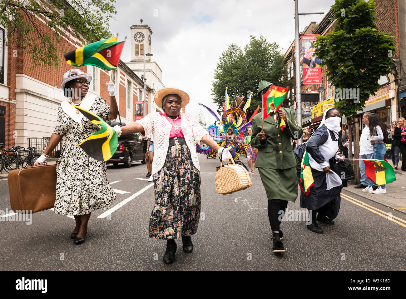 Women dressed to remember the contributions of the Windrush generation taking part in Acton Carnival Parade 2019. Acton Town Hall in background. Stock Photo