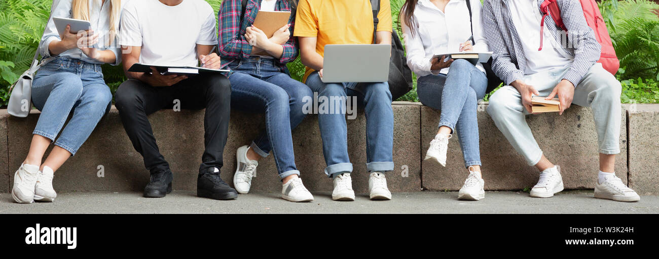 Students using laptop, resting in university campus Stock Photo