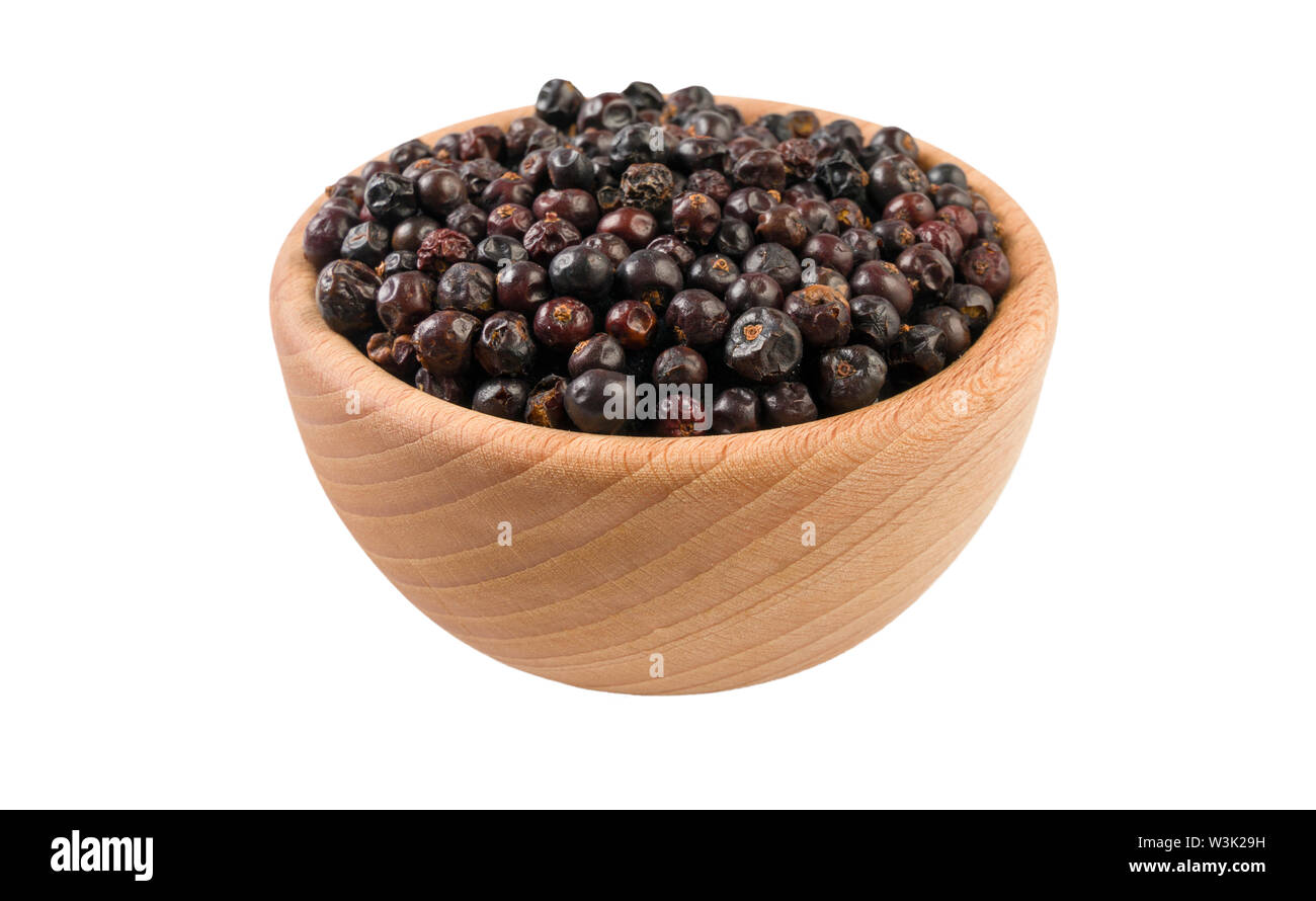 juniper berries in wooden bowl isolated on white background. 45 degree