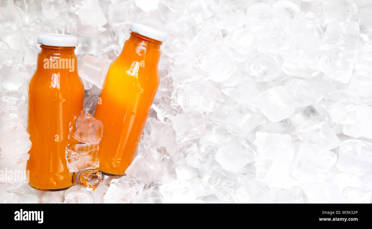 Detox refreshing orange drink in glass bottle on ice Stock Photo